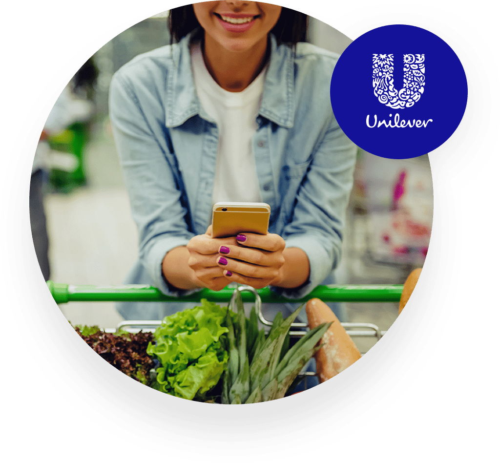 Femme souriant et tenant son smartphone avec le logo Unilever