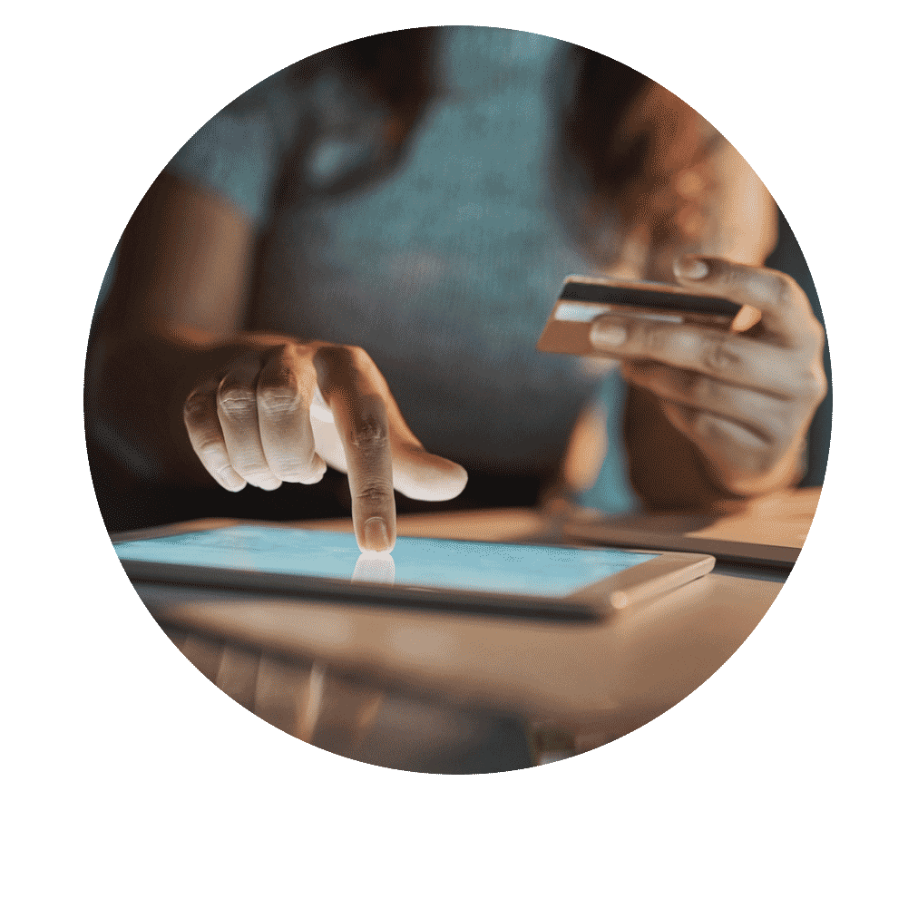 Person using a tablet and holding a credit card